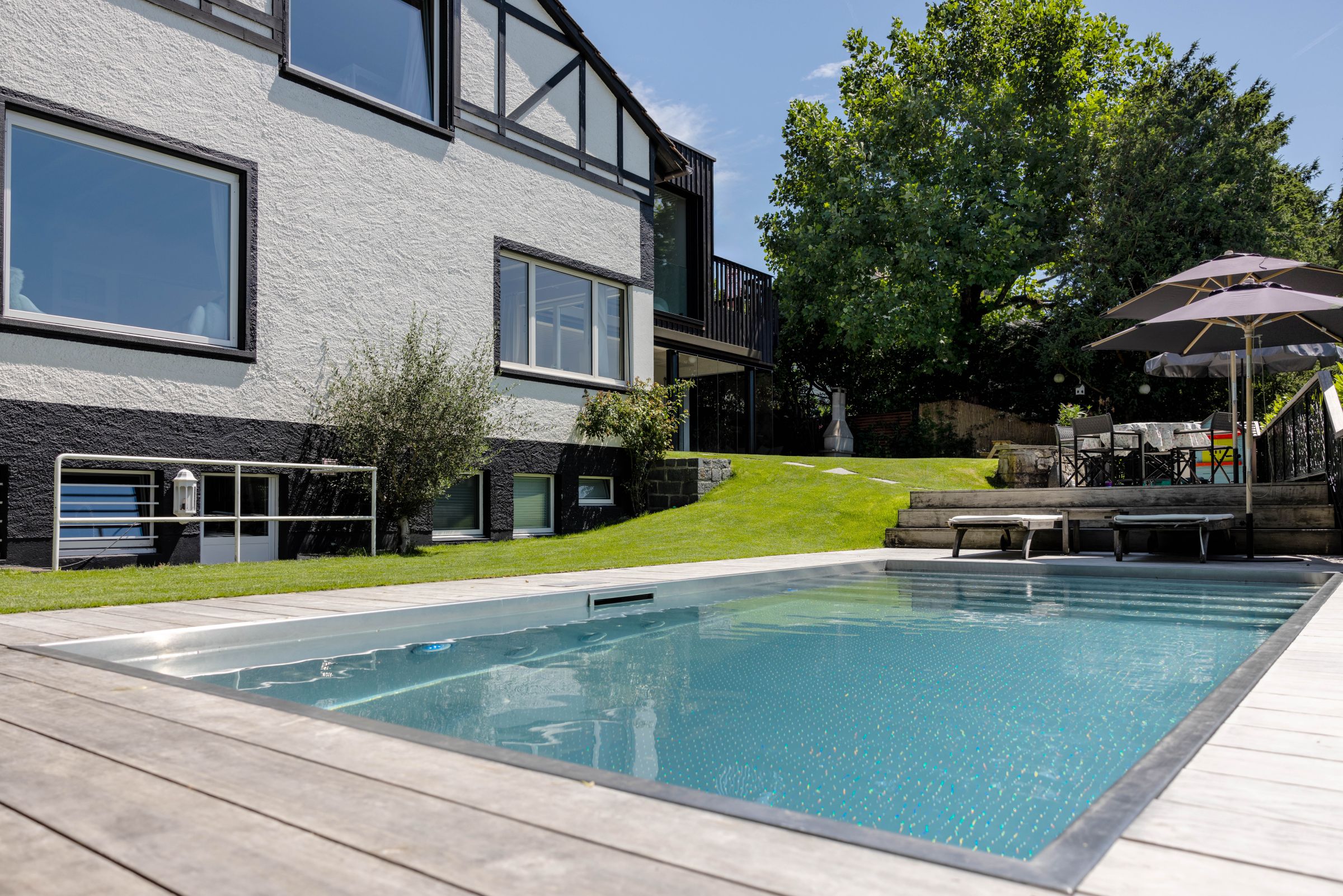 A remarkable feature of the garden is the wood pool deck that harmoniously blends with the hillside